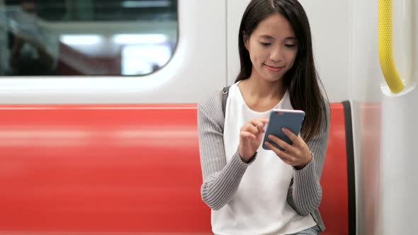 Woman using mobile phone on train