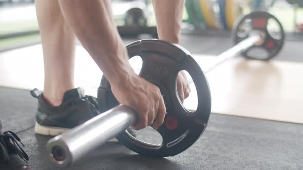 Young athlete caucasian guy exercising doing deadlift a barbell over his head fat burning workout.