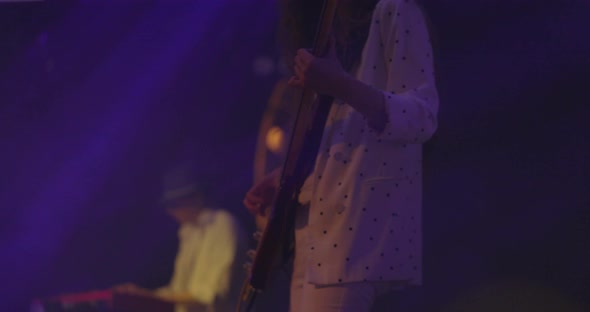 Woman Guitarist at a Rock Concert Plays Electric Guitar on the Open Stage