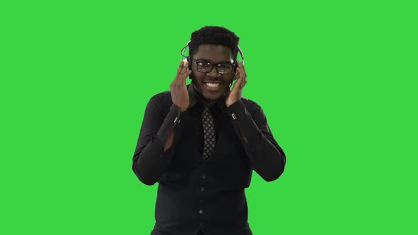 African American Man Holding Headphones with Both Hands and Grooving To Music While Looking 