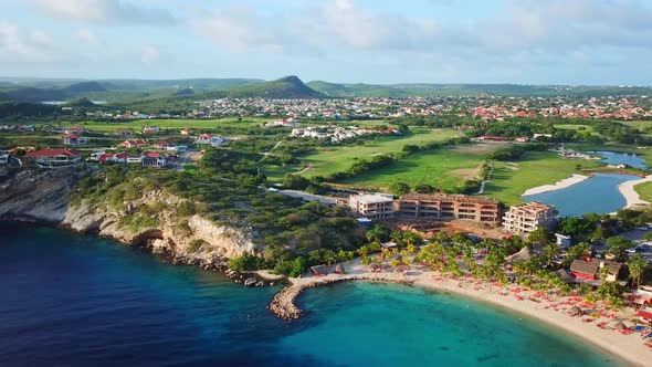 Aerial view tracking left of the Blue Bay beach of Curacao, Dutch Caribbean island, luxury golf reso