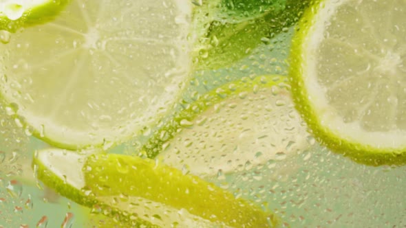 Lemon and Lime Cocktail Cooking Cold Lemonade Citrus Fruits in Water on Green Background Shooting of