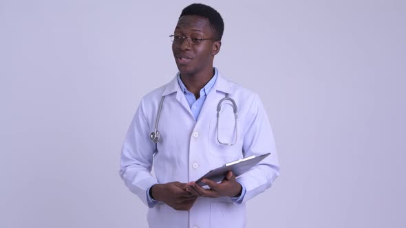 Young African Man Doctor Explaining Something While Holding Clipboard