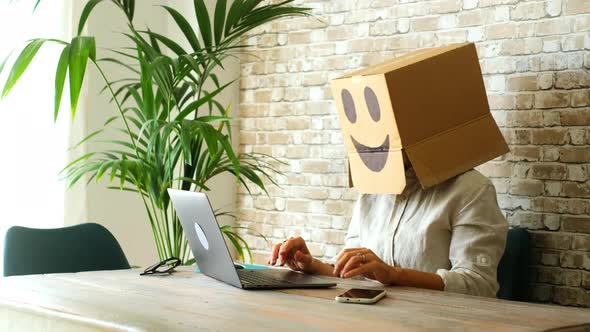 Happy and overjoyed successful people working on computer wearing smile box on head. Joyful online