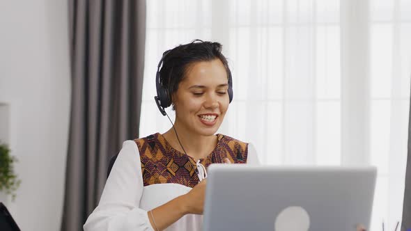 Excited Woman with Headphones During a Video Call