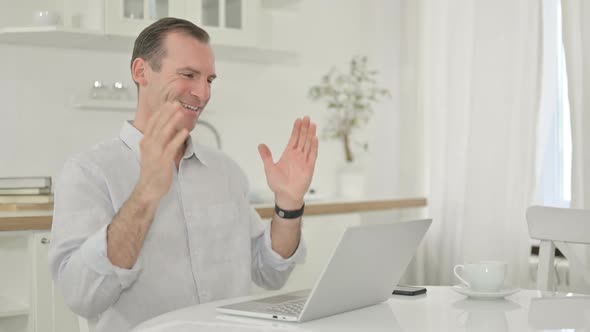Middle Aged Man Doing Video Call on Laptop at Home