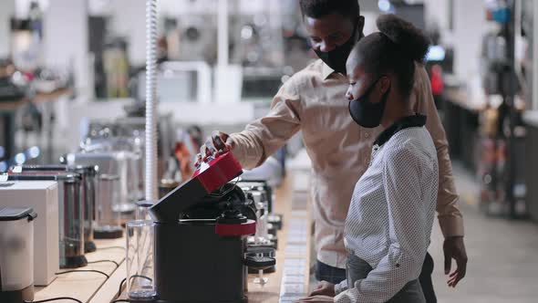 Black Man and Woman are Shopping in Hardware Store Choosing Coffee Machine in Home Appliances Shop
