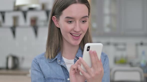 Portrait of Young Woman Celebrating Success on Smartphone