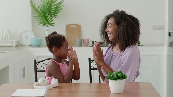 Mom and Daughter Playing Games Clapping Hands Smiling Having Fun Enjoying Time Together Sitting at