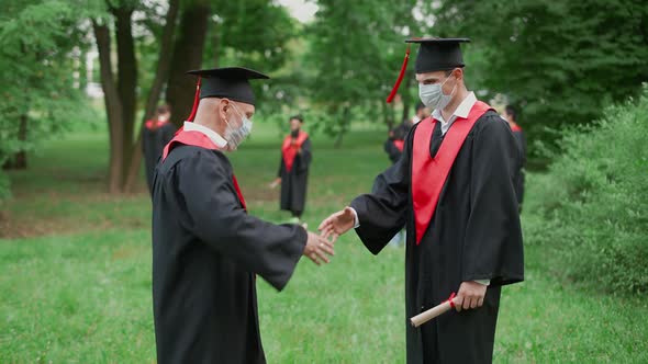 International University Graduation Teacher Congratulates the Man Student on Receiving Her Diploma