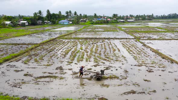 Farmer Using Walking Tractor Plowing in Rice Field To Prepare the Area To Grow Rice.