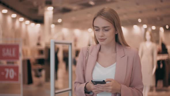 Beautiful Woman Using Mobile Phone in Mall