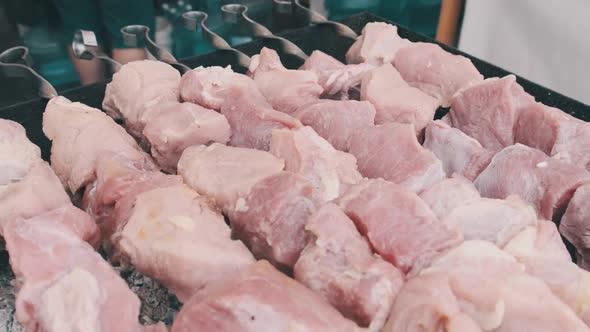 Raw Meat on Skewers Is Cooked on Grill at Street Food Festival. Slow Motion