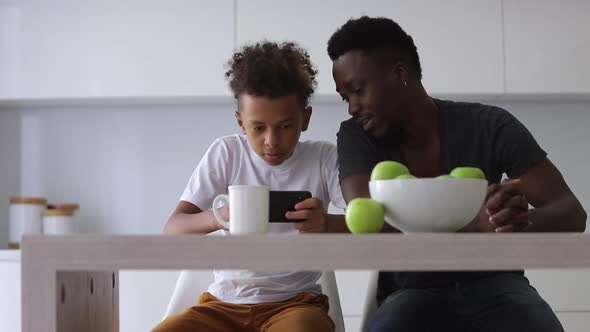 African Afro American Dad Watch Gamer Son Play Games on Smartphone Spbi