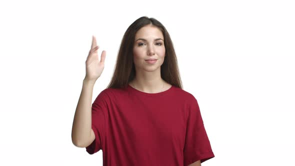 Sassy Attractive Woman with Long Dark Hair Wearing Red Tshirt Looking Confident and Saluting you
