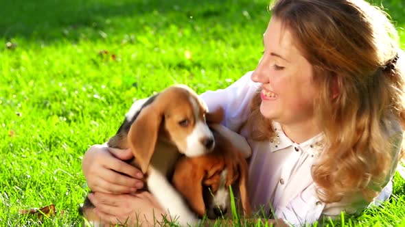 Happy Woman with a Dog Beagle Playing on Nature. Close Up