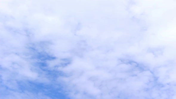 Movement of cumulus continuous clouds on a blue beautiful sky, background in motion, accelerated