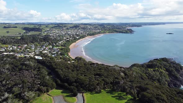 Rising aerial drone of Coopers Beach township and stunning curved bay Doubtless Bay, Northland in Ne