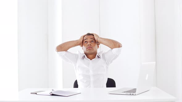 Nervous Young Successful Businessman Thinking Sitting at Workplace in Office