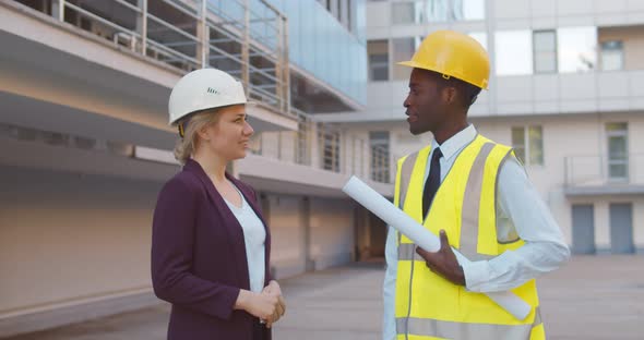 Diverse Contractor and Architect Shaking Hands Outside Construction Site