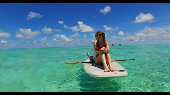 Two people posing on idyllic bay beach break by blue ocean with white sandy background of the Maldiv