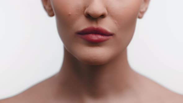 Closeup lips of woman smiles showing beautiful teeth. Woman smiles broadly on white background