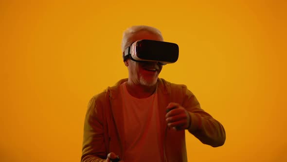 Senior Man in Virtual Reality Headset Playing Videogame, Hobby and Leisure Time