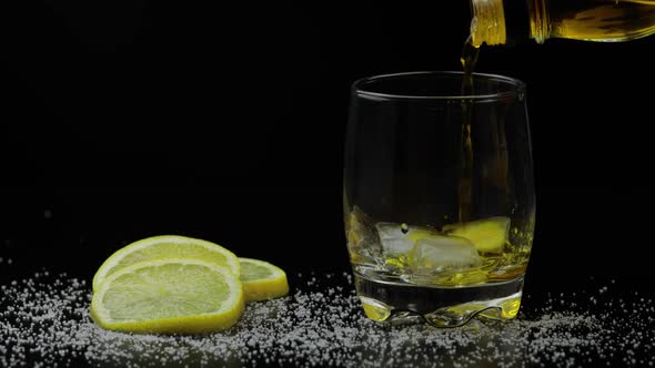 Whiskey with Ice. Pouring Whisky Rum From the Bottle on Black Background