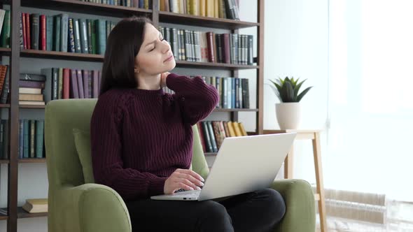 Tired Young Woman Working on Laptop in Office