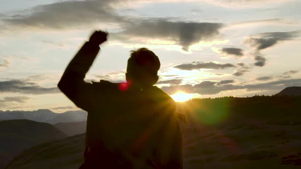 One Successful Happy Travel Man Standing Top Joy and Raises Hands Up