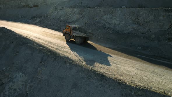 Career dump truck goes in a gold mine. Open pit mine quarrying