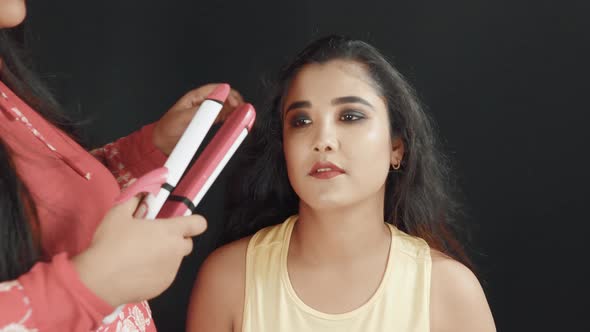 Close up of hairdresser making a hairstyle on beautiful woman's hair