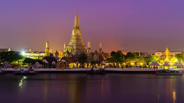 night to day time lapse of Wat Arun Temple with Chao Phraya river in Bangkok, Thailand