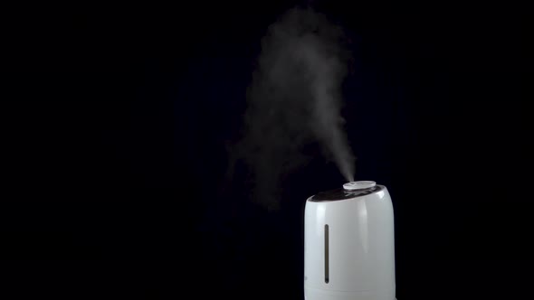 An Ultrasonic Humidifier Humidifies a Room with a Strong Stream of Steam on an Isolated Black