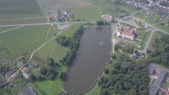 Aerial Shot with a Quadcopter of Mir Castle in Belarus Slow Motion. The Lake Is Located Near Mir