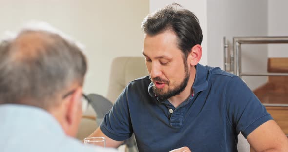 A Young Businessman in a Smart Tshirt Sits at the Table at Breakfast Lunch Dinner