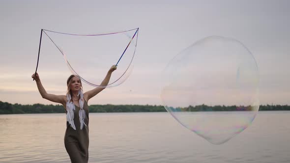 A Young Girl Artist Shows Magic Tricks Using Huge Soap Bubbles