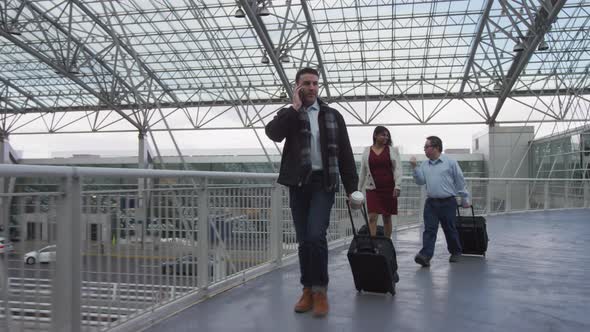 Businessman walking and talking on cell phone at airport