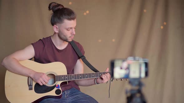 Man Recording Guitar Lessons for Students