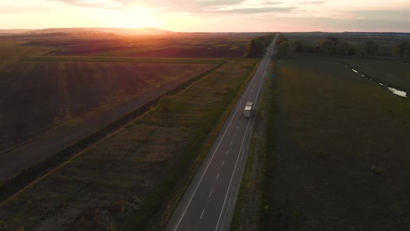 Aerial shot: vehicles, trucks and cars driving by road.