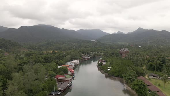 Aerial view of river and mountainous scenery, tilt up approach shot