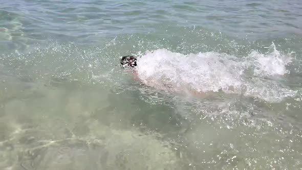 A Child is Having Fun in the Sea a Boy is Diving in Clear Sea Water on a Sunny Day