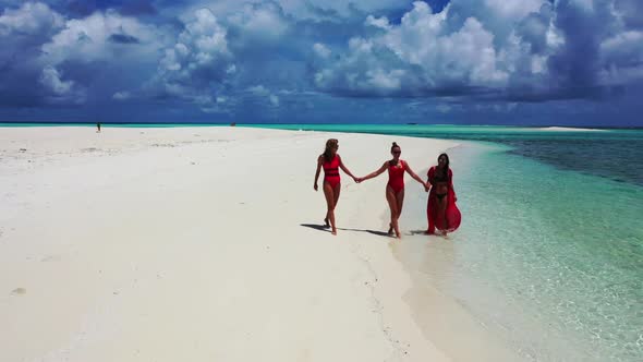 Female models tanning on relaxing coast beach time by aqua blue ocean with white sandy background of