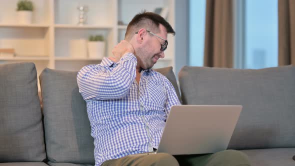 Hardworking Man with Laptop Having Neck Pain at Home 