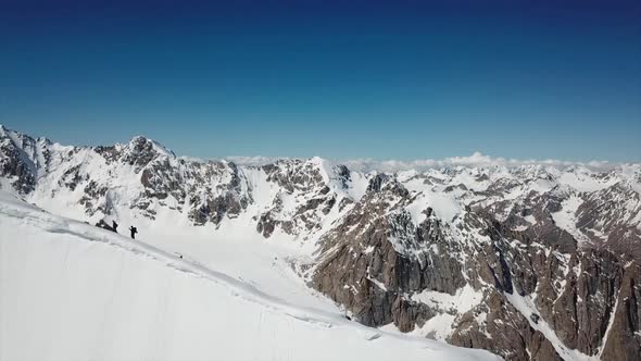 A Group of Climbers Climb To the Top of the Peak