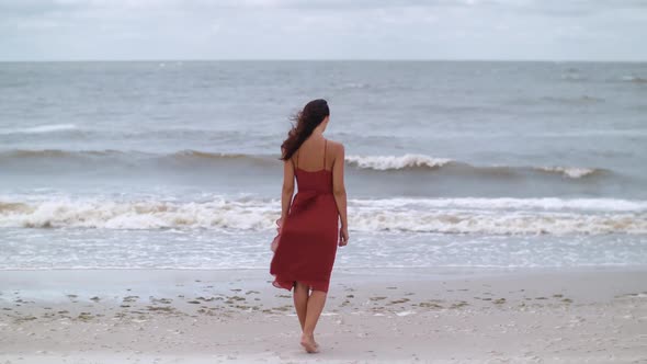 Woman in a Red on the Beach Cold Windy Weather