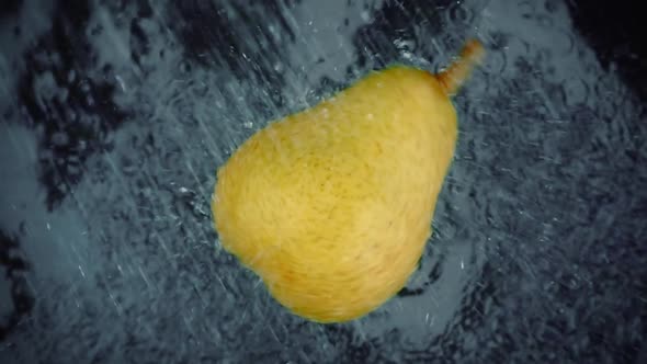 Pear with Clear Water Splash on Black Background