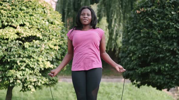 African American Woman Makes a Jump Rope Routine in a City Park