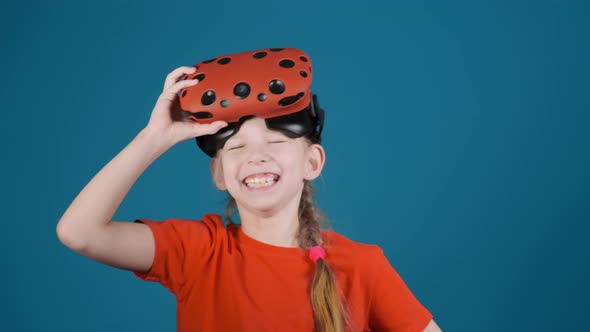 Little Girl Laughs Holding Virtual Reality Glasses on Head