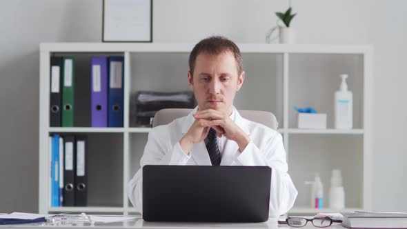 Professional medical doctor working in hospital office using computer technology.